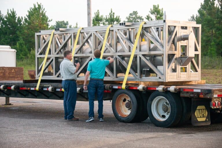 Two men checking the cargo of a semi truck