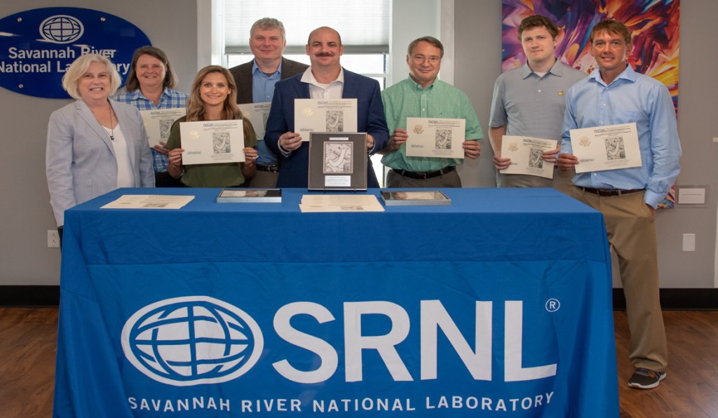 Members of the, now NWAL Qualified, Uranium Particle Production team receiving a Joule award from NNSA Office of International Safeguards, Safeguards Technology HQ Program lead, Arden Dougan.