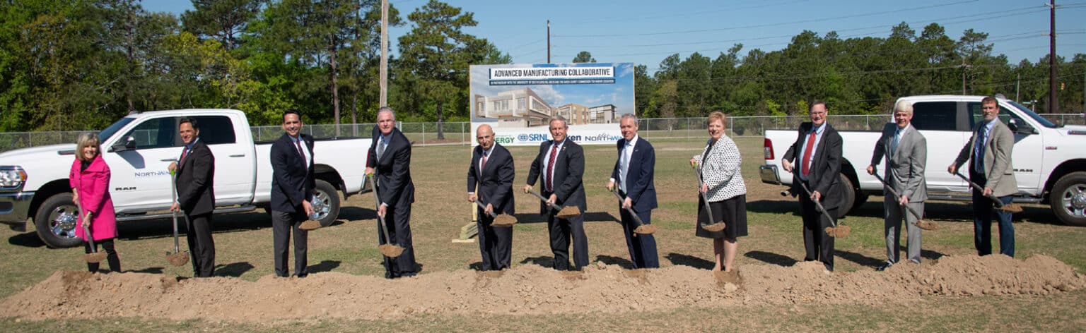 A group of people outside holding shovels, digging dirt