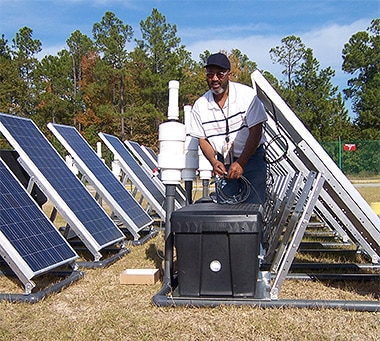 Man setting up solar panels that pumps out groundwater