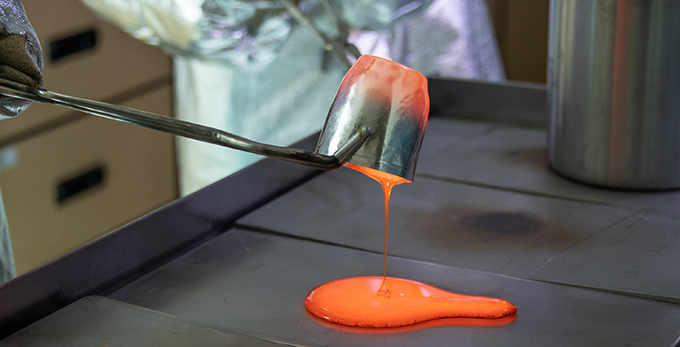 Molten glass pouring onto a metal surface