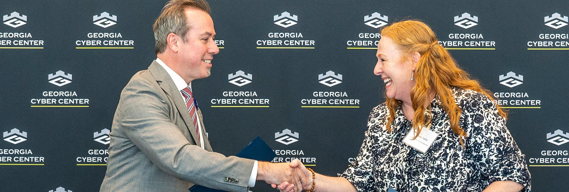 Close-up of a man and woman smiling and shaking hands